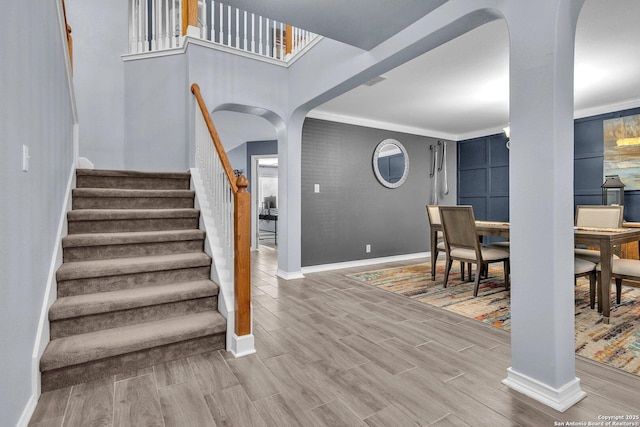 7715 Beechnut Oak, San Antonio, TX 78223 - stairs featuring arched walkways, baseboards, and wood finished floors