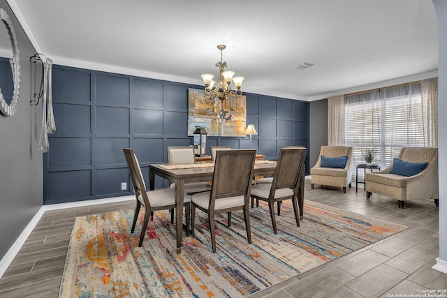 7715 Beechnut Oak, San Antonio, TX 78223 - dining space featuring a decorative wall, a chandelier, baseboards, and wood tiled floors