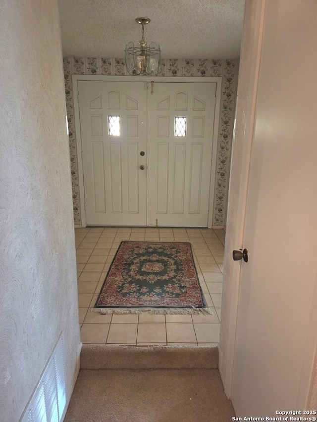 1319 Tideland, San Antonio, TX 78245 - foyer entrance with wallpapered walls, light tile patterned floors, and a chandelier
