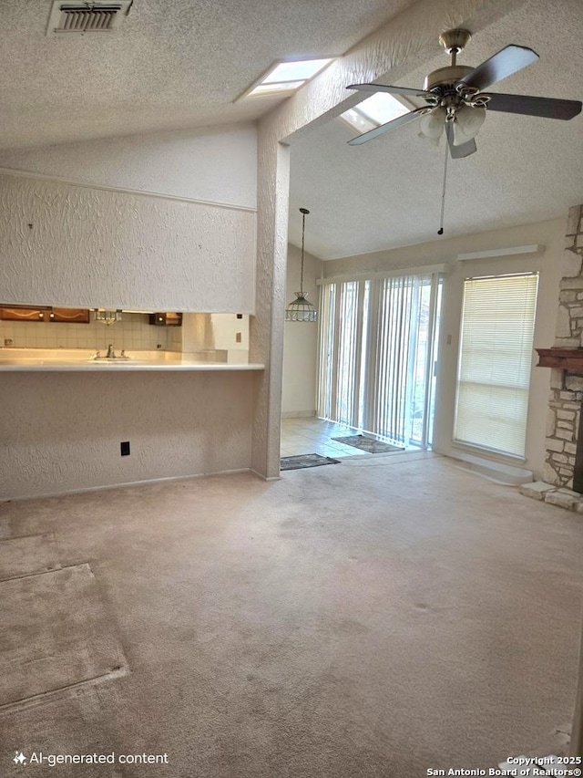 1319 Tideland, San Antonio, TX 78245 - unfurnished living room featuring vaulted ceiling, a ceiling fan, a textured ceiling, a textured wall, and a stone fireplace