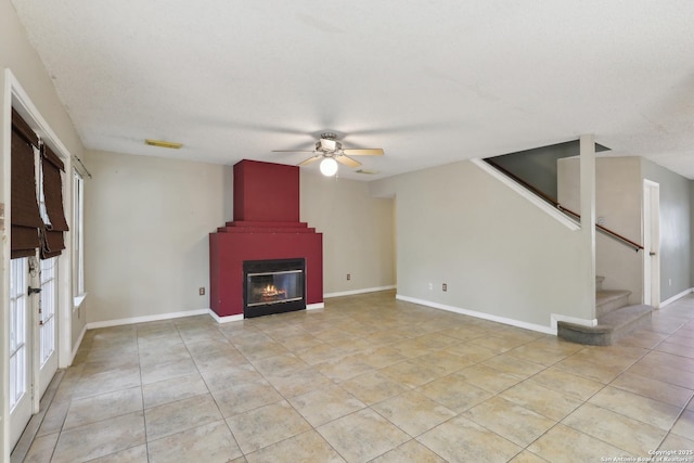15527 Legend Spgs, San Antonio, TX 78247 - unfurnished living room featuring a ceiling fan, light tile patterned floors, stairs, and a large fireplace