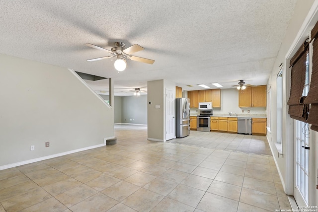 15527 Legend Spgs, San Antonio, TX 78247 - kitchen featuring appliances with stainless steel finishes, ceiling fan, open floor plan, light countertops, and baseboards