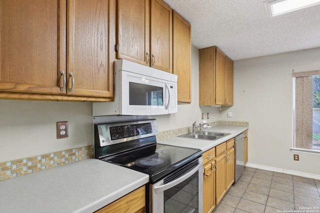 15527 Legend Spgs, San Antonio, TX 78247 - kitchen with stainless steel appliances, a sink, light countertops, baseboards, and light tile patterned flooring