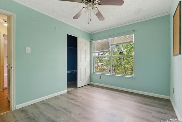 15527 Legend Spgs, San Antonio, TX 78247 - unfurnished bedroom featuring wood finished floors, baseboards, a closet, a textured ceiling, and crown molding
