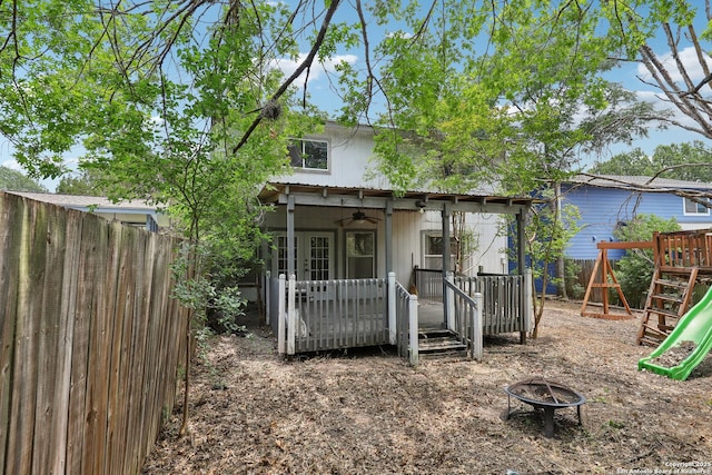 15527 Legend Spgs, San Antonio, TX 78247 - back of property featuring a deck, an outdoor fire pit, a fenced backyard, ceiling fan, and a playground