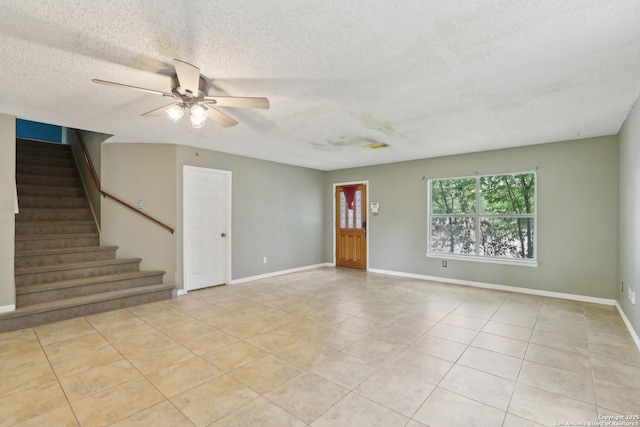 15527 Legend Spgs, San Antonio, TX 78247 - unfurnished living room featuring stairs, a textured ceiling, a ceiling fan, tile patterned flooring, and baseboards