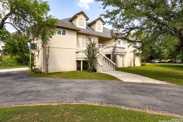 1434 Whispering Water, Spring Branch, TX 78070 - view of front of property with stucco siding, a front lawn, stairway, and driveway
