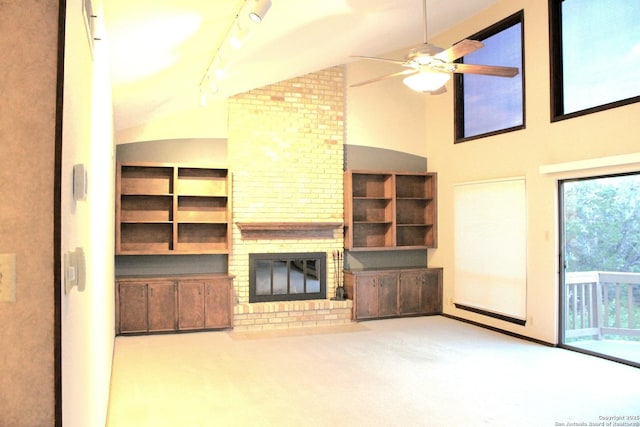 9118 Fox Briar, Boerne, TX 78006 - unfurnished living room featuring carpet flooring, lofted ceiling, ceiling fan, rail lighting, and a fireplace