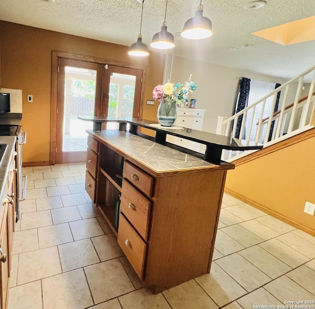 9208 Bowen, San Antonio, TX 78250 - kitchen featuring tile counters, a textured ceiling, light tile patterned flooring, brown cabinetry, and pendant lighting