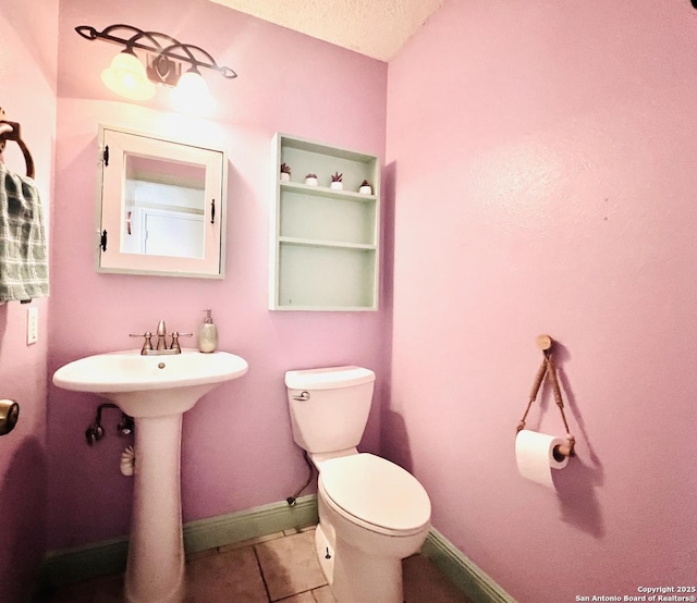 9208 Bowen, San Antonio, TX 78250 - half bath featuring toilet, baseboards, tile patterned floors, and a sink