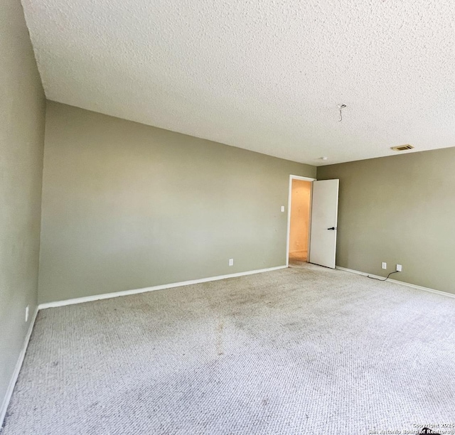 9208 Bowen, San Antonio, TX 78250 - empty room featuring light carpet, a textured ceiling, and baseboards