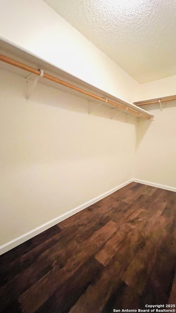 9208 Bowen, San Antonio, TX 78250 - spacious closet featuring dark wood-style flooring