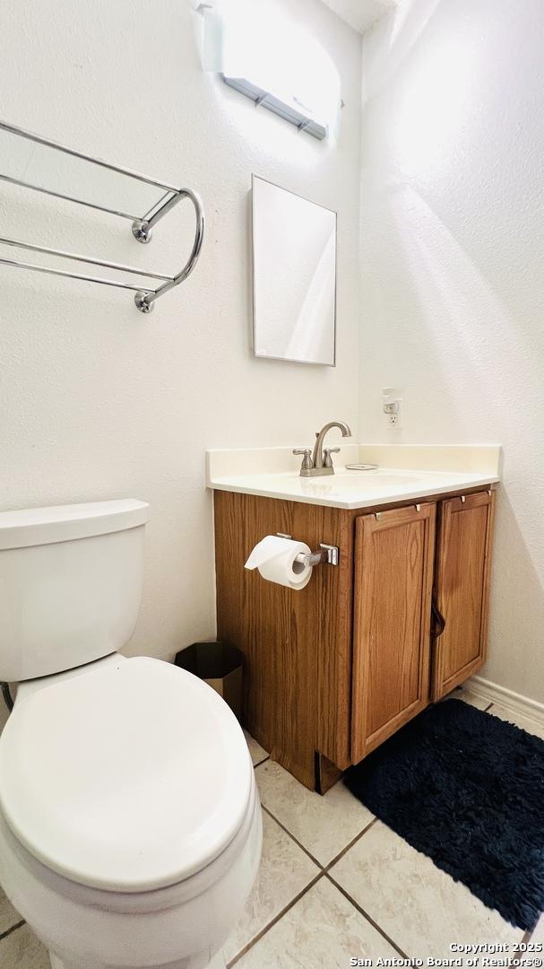 9208 Bowen, San Antonio, TX 78250 - half bath featuring vanity, a wall mounted air conditioner, toilet, and tile patterned floors