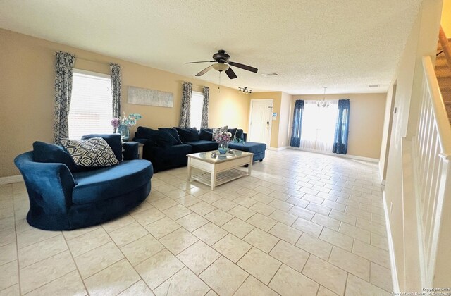 9208 Bowen, San Antonio, TX 78250 - living area featuring a chandelier, baseboards, a ceiling fan, light tile patterned floors, and a textured ceiling