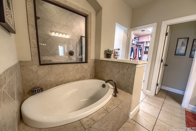 3811 Mira Mesa, San Antonio, TX 78259 - bathroom featuring a bath, a spacious closet, tiled shower, tile walls, and tile patterned floors