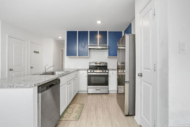 14418 Southton Basin, San Antonio, TX 78223 - kitchen with stainless steel appliances, a sink, under cabinet range hood, a peninsula, and light wood-style floors