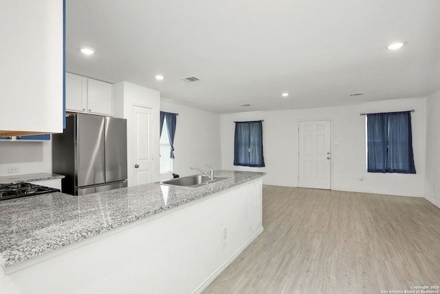 14418 Southton Basin, San Antonio, TX 78223 - kitchen featuring a sink, freestanding refrigerator, light stone countertops, light wood-style flooring, and recessed lighting