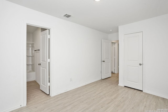 14418 Southton Basin, San Antonio, TX 78223 - unfurnished bedroom featuring light wood-type flooring, baseboards, and connected bathroom
