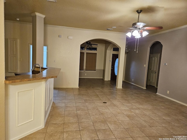3524 Angora Trl, Schertz, TX 78154 - unfurnished living room featuring a ceiling fan, arched walkways, crown molding, baseboards, and light tile patterned floors
