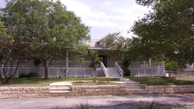 786 Stirrup, Spring Branch, TX 78070 - view of front of home with covered porch, stairs, metal roof, and a front yard