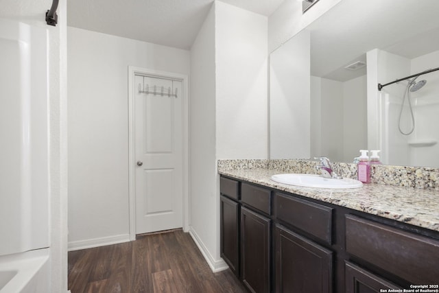 6631 Rosenthal Pass, San Antonio, TX 78252 - bathroom with wood finished floors, vanity, baseboards, and a shower
