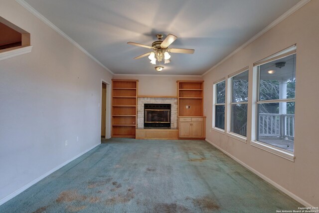 1306 Lytle, Kerrville, TX 78028 - unfurnished living room with baseboards, built in shelves, crown molding, a ceiling fan, and a glass covered fireplace