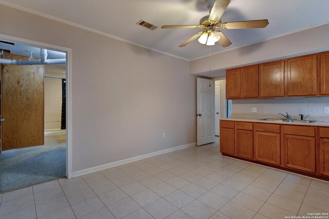 1306 Lytle, Kerrville, TX 78028 - kitchen with a sink, brown cabinets, light countertops, a ceiling fan, and crown molding