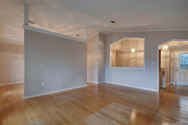 1306 Lytle, Kerrville, TX 78028 - unfurnished room featuring wood-type flooring, crown molding, baseboards, and arched walkways