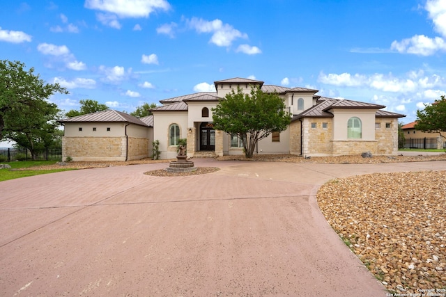 19223 Terra Rock, San Antonio, TX 78255 - mediterranean / spanish house featuring a standing seam roof, curved driveway, metal roof, stucco siding, and stone siding