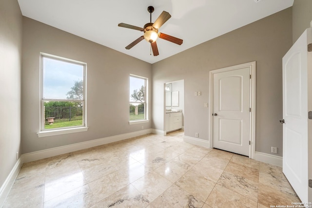 19223 Terra Rock, San Antonio, TX 78255 - unfurnished bedroom featuring multiple windows, baseboards, ensuite bathroom, and ceiling fan