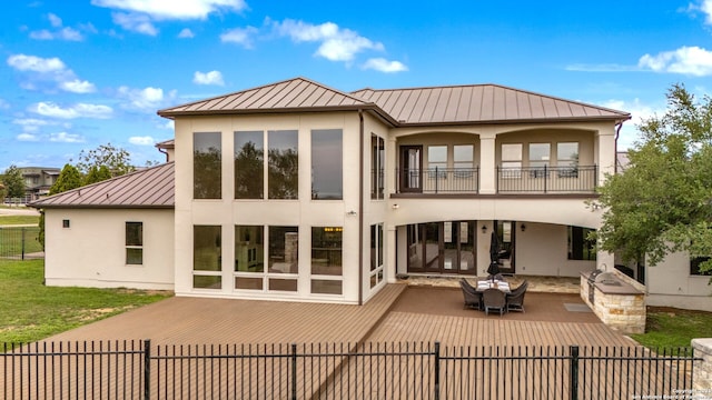 19223 Terra Rock, San Antonio, TX 78255 - rear view of house featuring a standing seam roof, stucco siding, metal roof, a balcony, and an outdoor kitchen