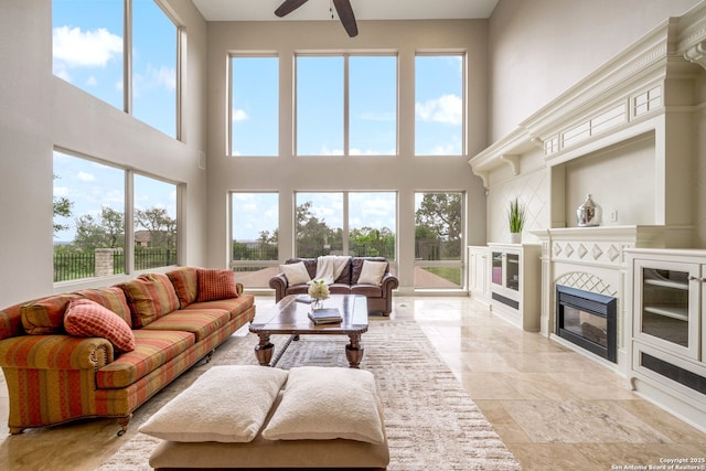 19223 Terra Rock, San Antonio, TX 78255 - living room with a towering ceiling, plenty of natural light, ceiling fan, and a tiled fireplace