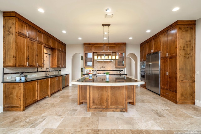 19223 Terra Rock, San Antonio, TX 78255 - kitchen featuring appliances with stainless steel finishes, arched walkways, a sink, tasteful backsplash, and recessed lighting