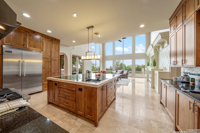 19223 Terra Rock, San Antonio, TX 78255 - kitchen with stainless steel built in fridge, a sink, arched walkways, tasteful backsplash, and recessed lighting