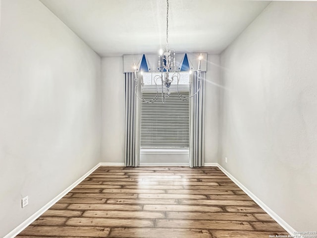106 Serenity, Boerne, TX 78006 - unfurnished dining area with a chandelier, hardwood / wood-style floors, and baseboards