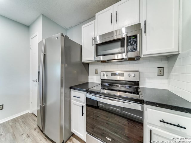 16402 Blanco Ky, San Antonio, TX 78247 - kitchen featuring stainless steel appliances, light wood-style flooring, white cabinetry, tasteful backsplash, and dark stone countertops