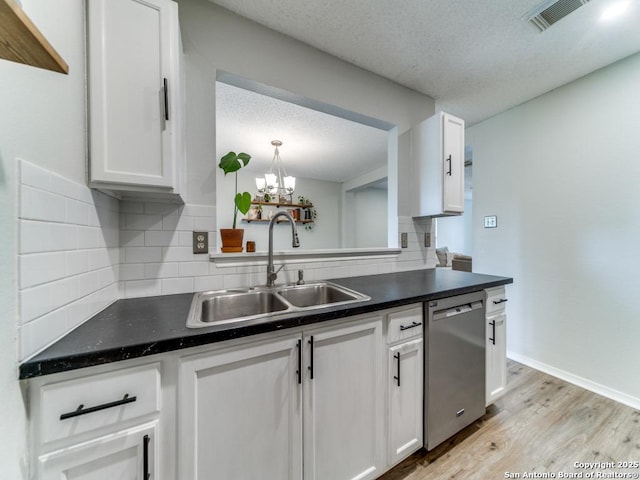 16402 Blanco Ky, San Antonio, TX 78247 - kitchen with stainless steel dishwasher, a sink, dark countertops, white cabinetry, and a textured ceiling