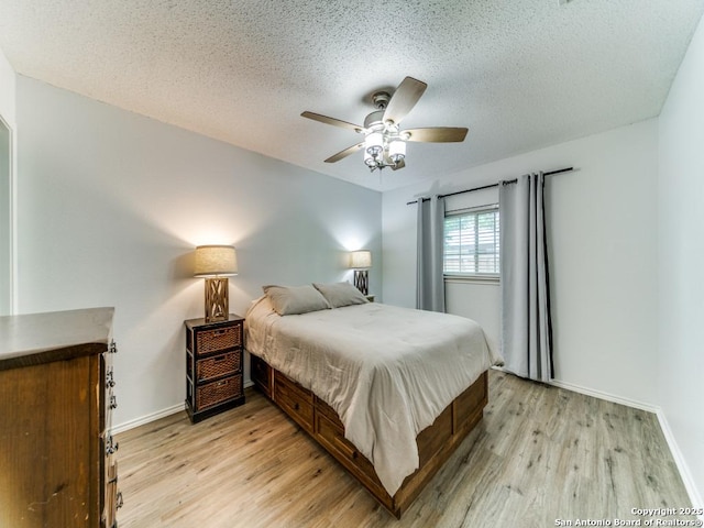 16402 Blanco Ky, San Antonio, TX 78247 - bedroom with light wood-style flooring, baseboards, a textured ceiling, and a ceiling fan
