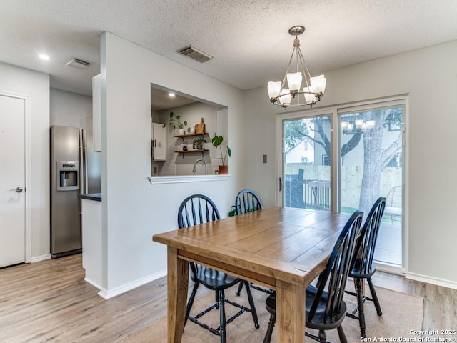 16402 Blanco Ky, San Antonio, TX 78247 - dining space featuring light wood-style floors, a chandelier, baseboards, and a textured ceiling