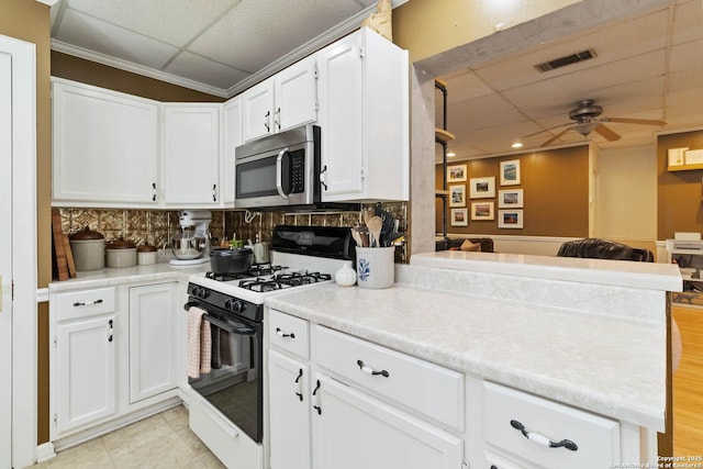 859 Pine St, New Braunfels, TX 78130 - kitchen with gas range, a paneled ceiling, stainless steel microwave, a ceiling fan, and open floor plan
