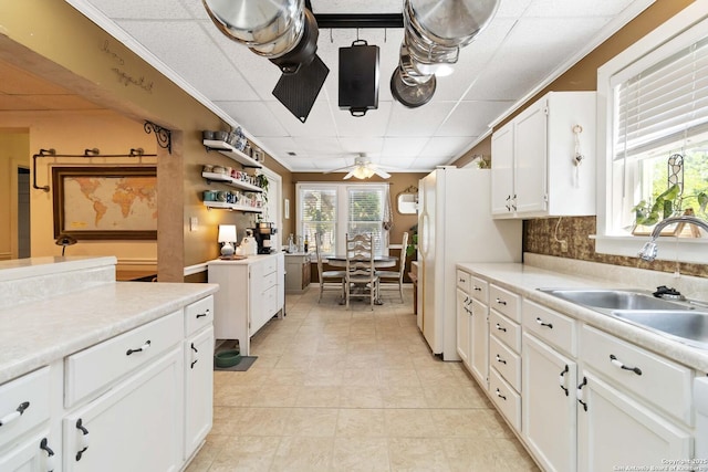 859 Pine St, New Braunfels, TX 78130 - kitchen featuring a sink, a ceiling fan, light tile patterned flooring, white cabinetry, and light countertops