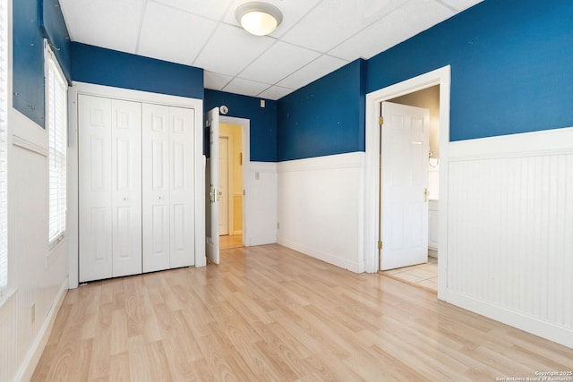 859 Pine St, New Braunfels, TX 78130 - unfurnished bedroom with wood finished floors, wainscoting, a closet, a drop ceiling, and baseboards