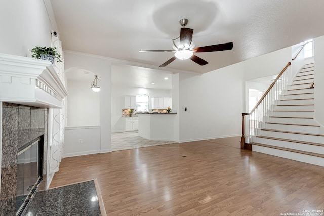 21746 Luisa, San Antonio, TX 78259 - unfurnished living room featuring a ceiling fan, light wood finished floors, stairway, a fireplace, and arched walkways