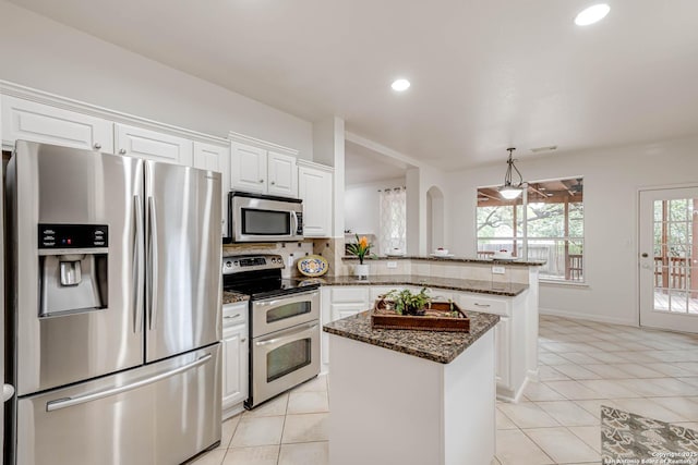 21746 Luisa, San Antonio, TX 78259 - kitchen with appliances with stainless steel finishes, a peninsula, white cabinetry, light tile patterned floors, and a kitchen island