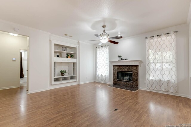 21746 Luisa, San Antonio, TX 78259 - unfurnished living room featuring ceiling fan, built in features, baseboards, wood finished floors, and ornamental molding