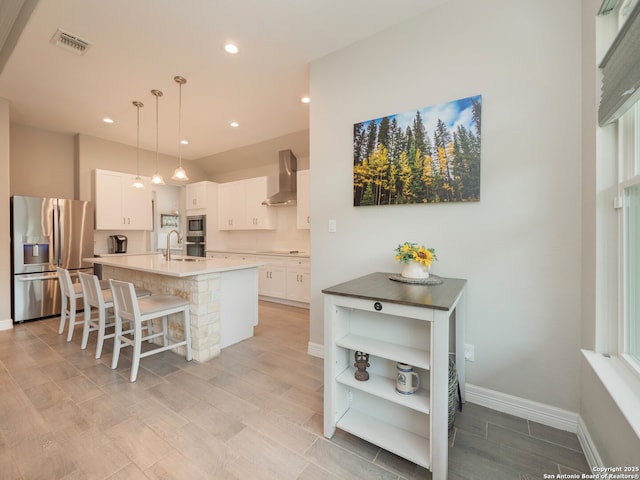 1006 Rock Shelter, San Antonio, TX 78260 - kitchen with stainless steel refrigerator with ice dispenser, a sink, wall chimney exhaust hood, an island with sink, and white cabinetry