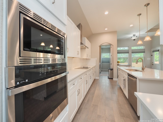1006 Rock Shelter, San Antonio, TX 78260 - kitchen featuring appliances with stainless steel finishes, a sink, light countertops, wall chimney range hood, and white cabinets