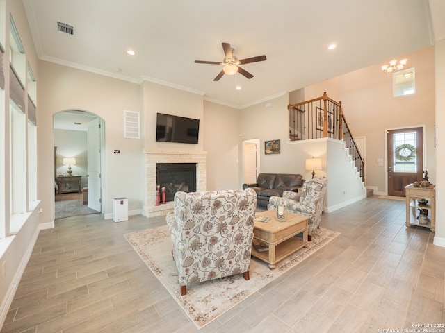 1006 Rock Shelter, San Antonio, TX 78260 - living room with arched walkways, ceiling fan, light wood-style floors, stairway, and a stone fireplace