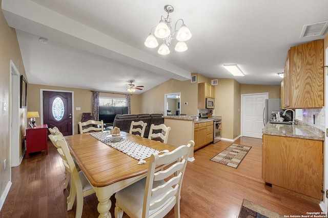11301 Ford, Adkins, TX 78101 - dining area featuring light wood-style floors, a ceiling fan, a chandelier, baseboards, and vaulted ceiling