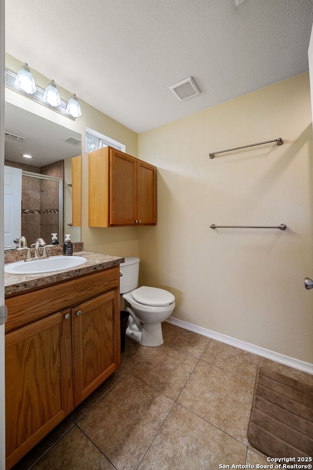 11301 Ford, Adkins, TX 78101 - bathroom featuring vanity, tiled shower, tile patterned floors, toilet, and baseboards